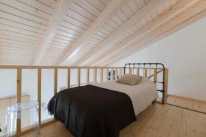 a bed in a room with a wooden ceiling at Bohemian Antique Guesthouse in Odeceixe