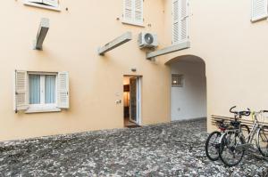 two bikes parked outside a building with windows at IL VICOLETTO Appartamento vacanza in Cesena