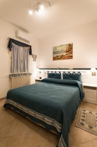 a bedroom with a large bed with a green blanket at IL VICOLETTO Appartamento in Cesena
