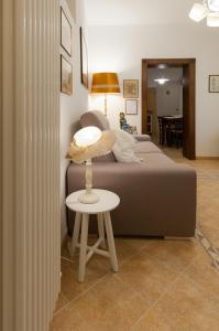 a bedroom with a bed and a stool with a table at IL VICOLETTO Appartamento in Cesena