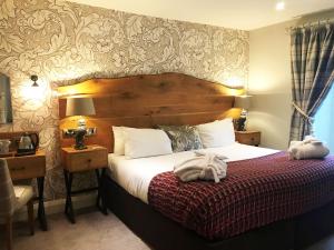 a bedroom with a bed, a desk and a lamp at Royal Oak at Keswick in Keswick