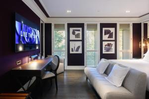 a bedroom with a couch and a bed and a tv at Seventy Barcelona in Barcelona