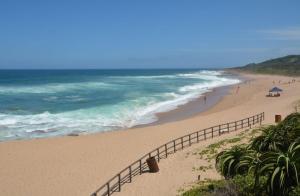 a beach with people walking on the sand and the ocean at IRONWOOD LODGE in Pennington