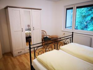 - une chambre avec un lit, une commode et une fenêtre dans l'établissement Waldnest am Semmering, à Semmering