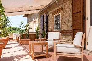 un patio con sillas, una mesa y un edificio en Fattoria Pian Di Rocca, en Castiglione della Pescaia