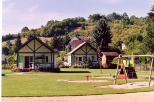 une aire de jeux en face d'une maison dans l'établissement Village-Chalets Le Rû du Pré, à Cravant