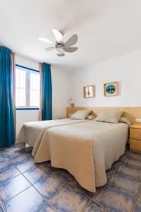 a bedroom with two beds and a ceiling fan at Nautilus Lanzarote in Puerto del Carmen