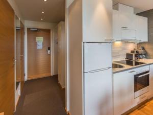 a kitchen with white cabinets and a refrigerator at Holiday Home Ski chalets 6203- during winter season 2 by Interhome in Ylläs