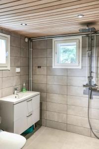 a bathroom with a sink and a shower at Holiday Home Pajalan hirsitupa by Interhome in Nissi