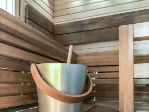 a metal bucket in a room with a wooden wall at Holiday Home Pajalan hirsitupa by Interhome in Nissi