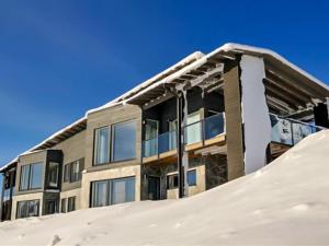 a building with a pile of snow in front of it at Holiday Home Rukavuorenhuippu 23 a by Interhome in Ruka