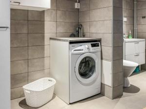 a washing machine in a bathroom with a toilet at Holiday Home Pajalan hirsitupa by Interhome in Nissi