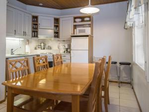 a kitchen with a wooden table and chairs in a kitchen at Holiday Home Alppitalo punatähti 7 apt 4 by Interhome in Tahkovuori