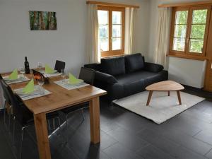 - un salon avec une table et un canapé dans l'établissement Apartment Bijou Eggetli by Interhome, à Zweisimmen