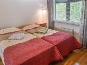 a bedroom with two beds with red covers and a window at Holiday Home Alppitalo punatähti 7 apt 4 by Interhome in Tahkovuori +8 photos