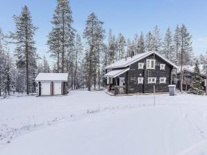 a log cabin in the snow with trees at Holiday Home Uuvana by Interhome in Äkäslompolo
