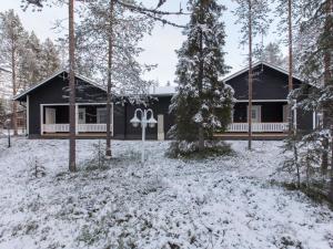 a house in the woods with snow on the ground at Holiday Home Pihkala 1 by Interhome in Äkäslompolo