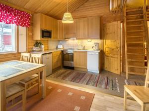 アカスロンポロにあるHoliday Home Nutukas-ylläksen lapikas by Interhomeのキッチン(木製キャビネット、テーブル付)、ダイニングルームが備わります。