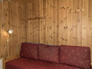 - un canapé rouge dans une chambre dotée de murs en bois dans l'établissement Holiday Home Ylläskarpalo 1 päätyhuoneisto by Interhome, à Äkäslompolo 8 autres photos
