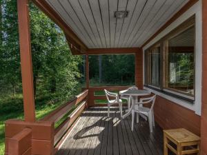 a screened porch with a table and chairs on it at Holiday Home 6440 by Interhome in Pihlajaniemi