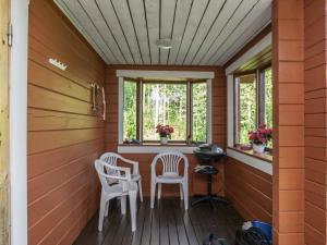 a porch with two chairs and two windows at Holiday Home 6440 by Interhome in Pihlajaniemi