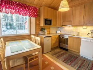 a kitchen with a table and a dining room at Holiday Home Nutukas-ylläksen lapikas by Interhome in Äkäslompolo +8 photos