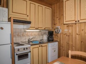 アカスロンポロにあるHoliday Home Ylläskarpalo 2 keskimmäinen by Interhomeのキッチン(白い家電製品、木製キャビネット付)