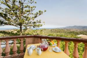 een tafel met een theeset op een balkon bij Hotel Villa Gli Asfodeli in Tresnuraghes