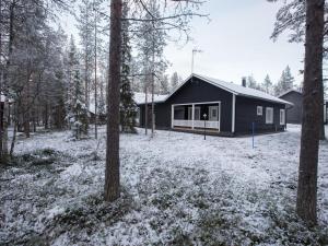 a house in the woods with snow on the ground at Holiday Home Pihkala 1 by Interhome in Äkäslompolo