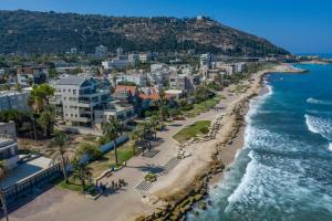 eine Luftansicht auf einen Strand mit Gebäuden und das Meer in der Unterkunft PORT CITY HAIFA - BAT GALIM oceanfront luxury in Haifa