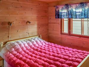 a large pink bed in a room with a window at Holiday Home Villa hytönen 1 by Interhome in Äkäslompolo