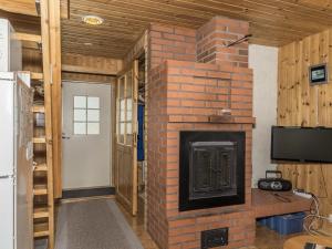 アカスロンポロにあるHoliday Home Ylläskarpalo 1 päätyhuoneisto by Interhomeのテレビ付きのリビングルームのレンガ造りの暖炉