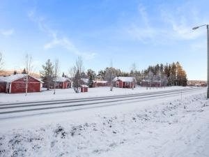 a snow covered street with houses and a street light at Holiday Home Nutukas-ylläksen lapikas by Interhome in Äkäslompolo