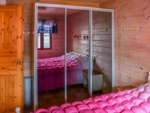 a bedroom with a pink bed in a wooden room at Holiday Home Villa hytönen 1 by Interhome in Äkäslompolo