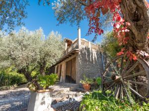 uma vista exterior da casa com uma oliveira em Holiday Home Cala Tuent by Interhome em Cala Tuent