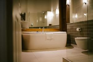 a bathroom with a tub and a toilet and a sink at Jesmond Dene House in Newcastle upon Tyne