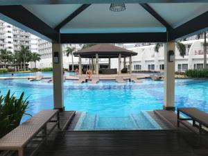 a swimming pool with chairs and a gazebo at BEST Q CONDO w/ Great View in Manila