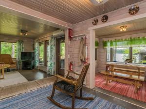 un soggiorno con una sedia a dondolo e una vasca di Holiday Home Uimaranta by Interhome a Längelmäki