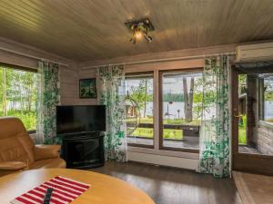 un soggiorno con TV e una grande finestra di Holiday Home Uimaranta by Interhome a Längelmäki Altre 13 foto