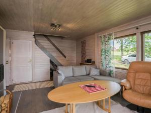 een woonkamer met een bank en een tafel bij Holiday Home Uimaranta by Interhome in Längelmäki