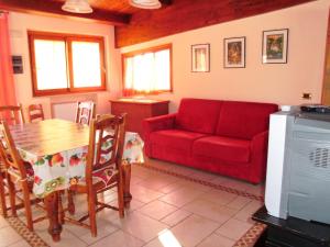 sala de estar con sofá rojo y mesa en Villino Rosalia, en Sperlonga