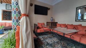 una sala de estar con un sofá y una mesa en Riad La Porte des 5 Jardins, en Marrakech
