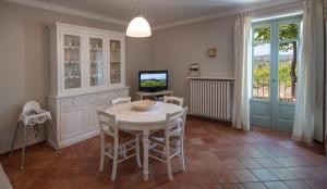 a dining room with a table and a television at Cascina Meriame in Serralunga d'Alba