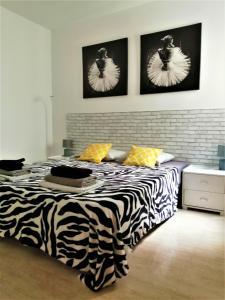 a bedroom with a zebra print bed with two pictures on the wall at Unigue Design Apartment, Gandia in Gandía