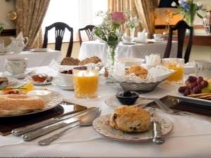 una mesa con platos de comida y vasos de zumo de naranja en Brick Walls Hotel, en Omsk