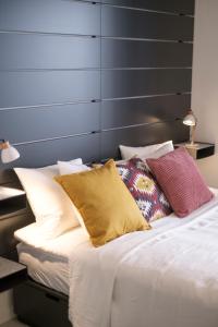 Bett mit Kissen und blauem Kopfteil in der Unterkunft Mini loft with terrace in Brüssel