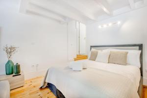 um quarto branco com uma cama grande e lençóis brancos em Santa Catarina Charming Loft no Porto