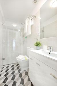 uma casa de banho branca com um WC e um chuveiro em Santa Catarina Charming Loft no Porto