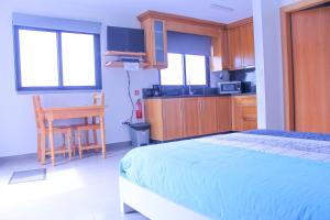 Un dormitorio con una cama y una mesa y una cocina. en Studio Two | Massapez | Fajã da Ovelha | Calheta, en Fajã da Ovelha