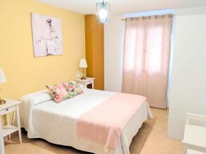 1 dormitorio con cama blanca y ventana en Casa Charo, en Santa Cruz de la Palma